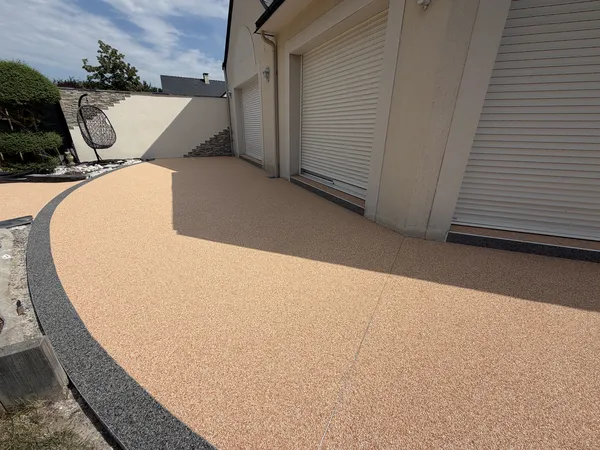 Allée de garage en moquette de pierre ocre avec caniveau