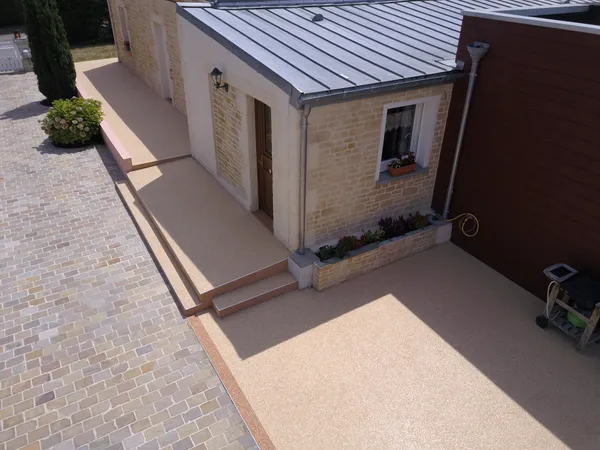 Entrée de maison avec terrasse et marches en moquette de pierre, vue drone