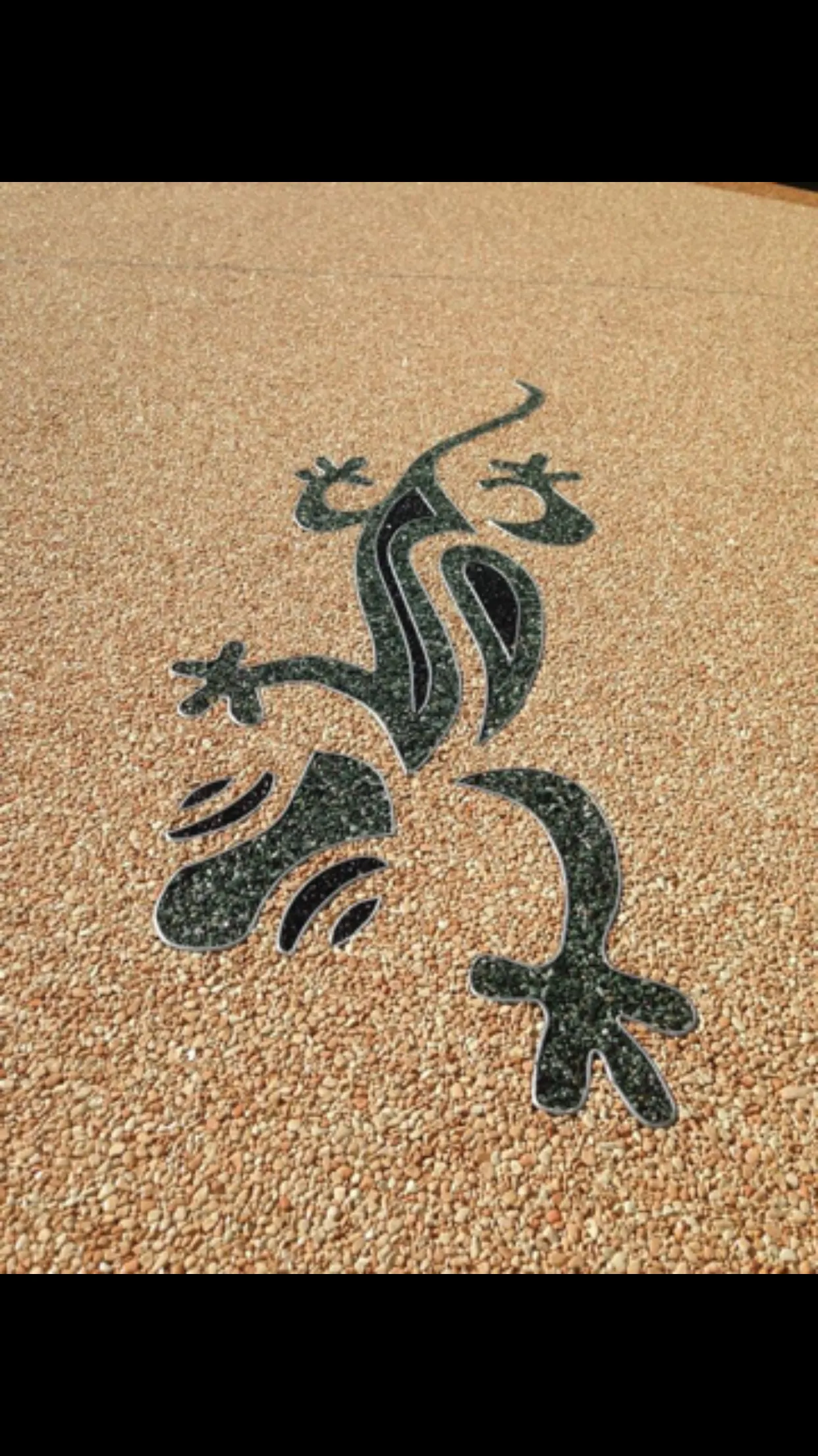 Motif gecko incrusté dans une moquette de pierre