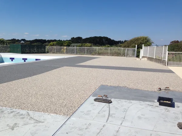 Plage de piscine en moquette de pierre grise et beige