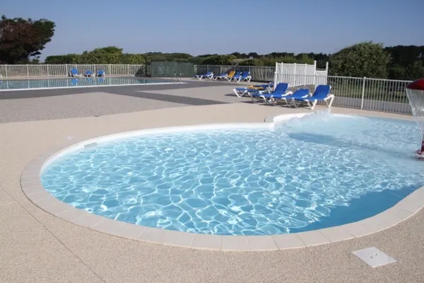 Plage de piscine d'un camping en moquette de pierre claire