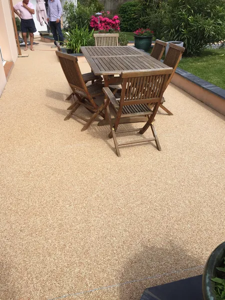 Terrasse en moquette de pierre beige avec mobilier en bois