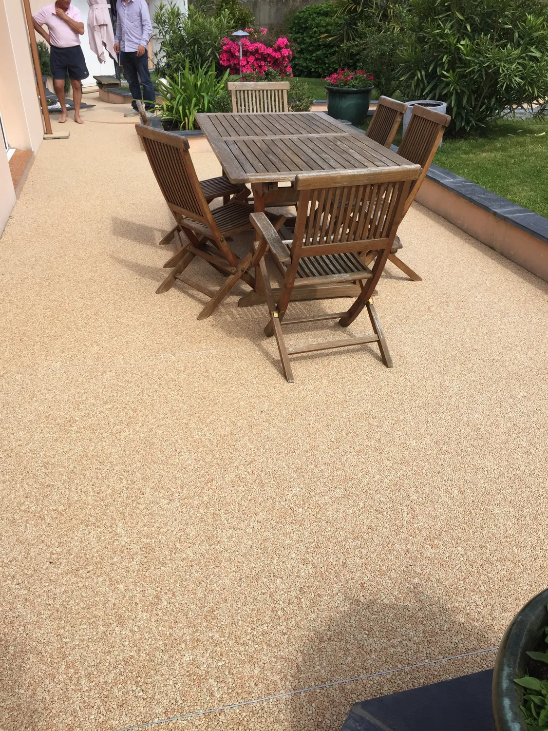 Terrasse en moquette de pierre beige avec mobilier en bois