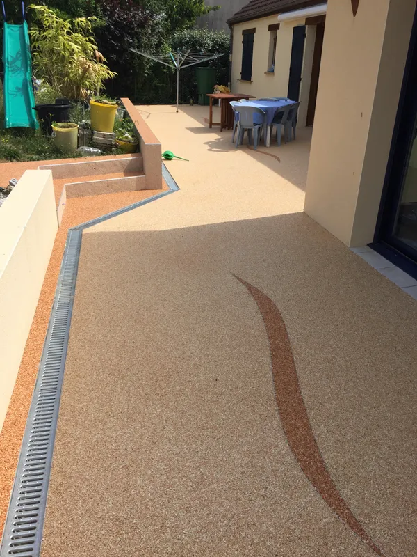 Terrasse en moquette de pierre bicolore avec marches et caniveau