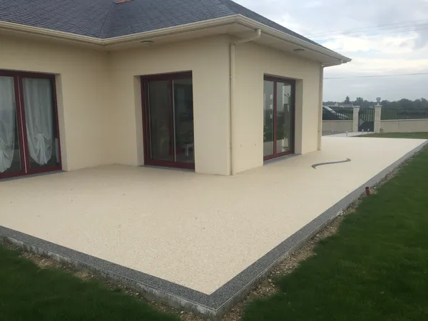 Terrasse en moquette de pierre crème contre la maison