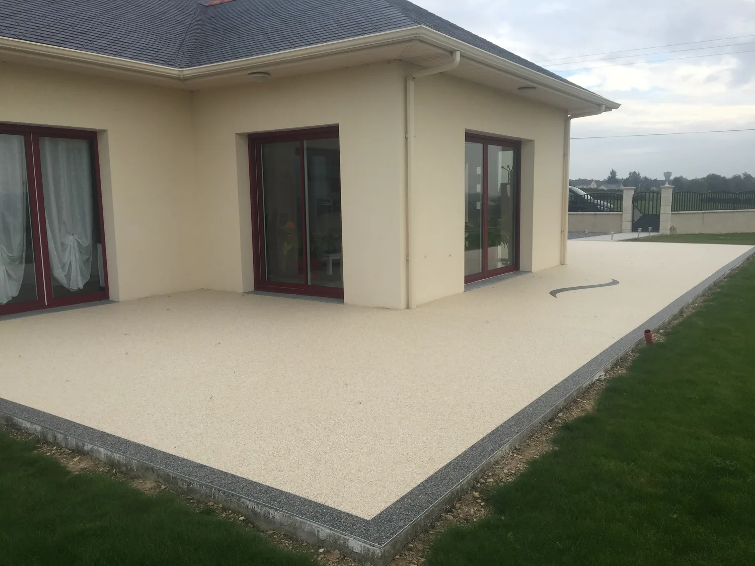 Terrasse en moquette de pierre crème contre la maison