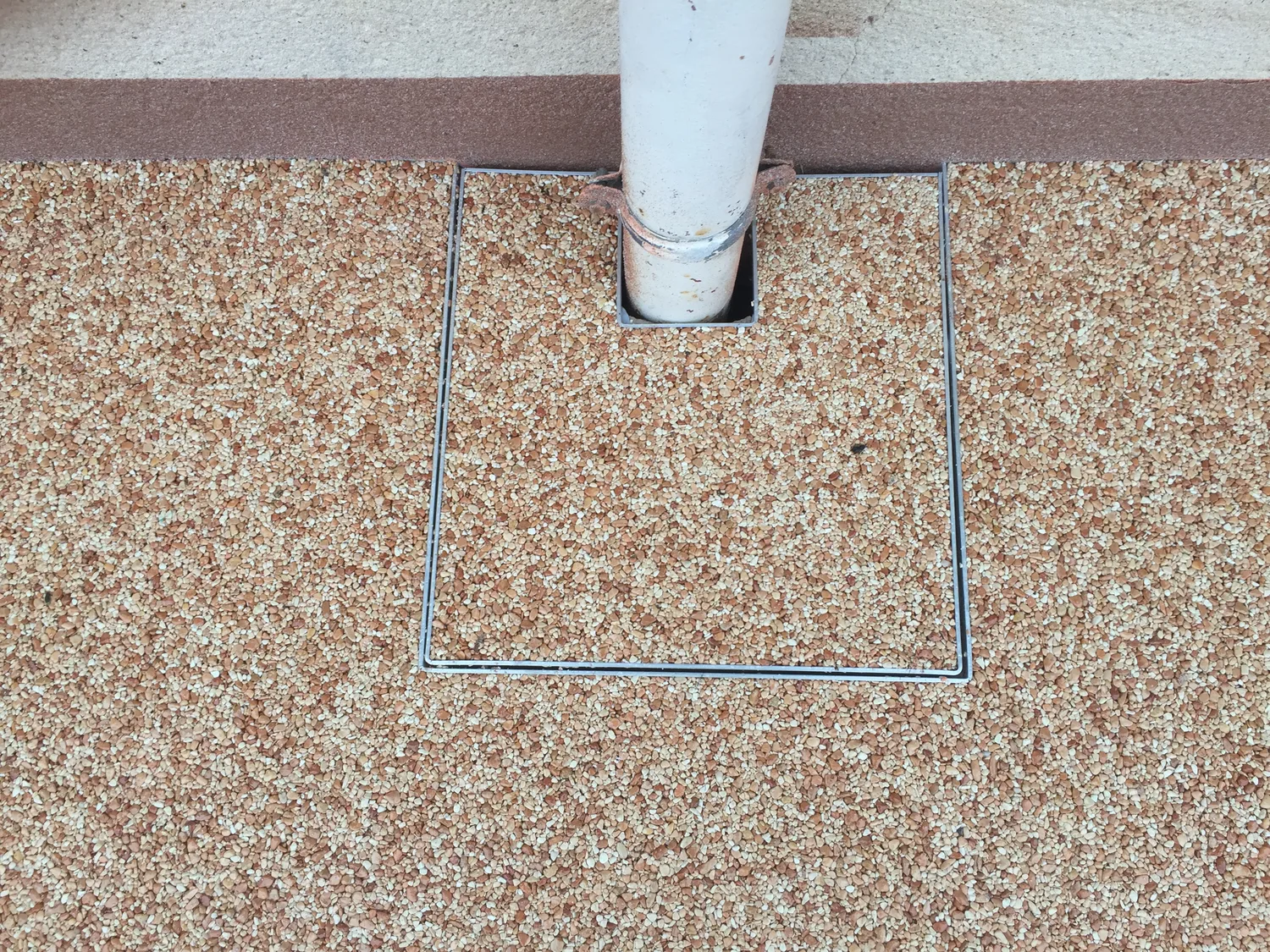 Détail d'une terrasse en moquette de pierre avec avaloir intégré
