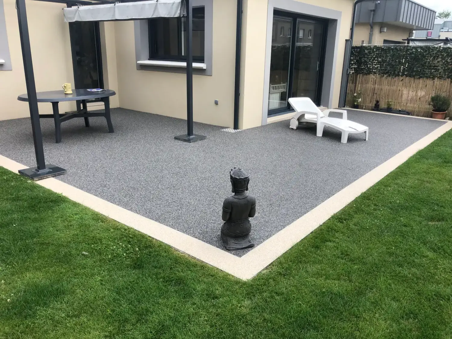 Terrasse en moquette de pierre grise avec bordure beige
