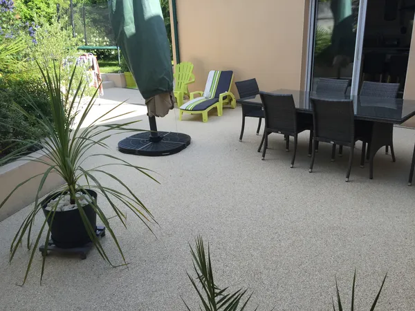 Terrasse en moquette de pierre grise avec salon de jardin