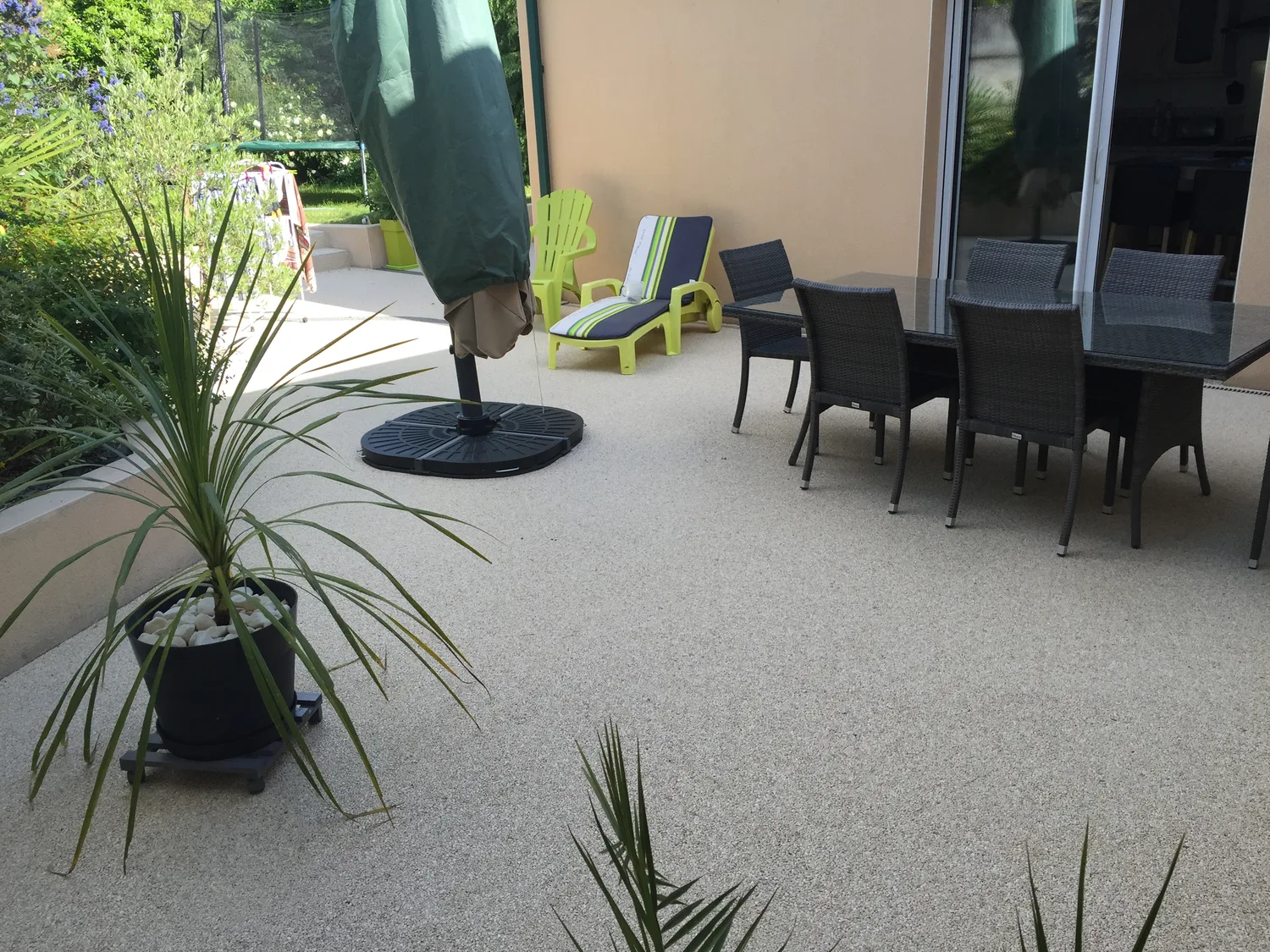 Terrasse en moquette de pierre grise avec salon de jardin