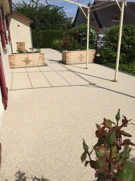 Terrasse en moquette de pierre avec rosier grimpant
